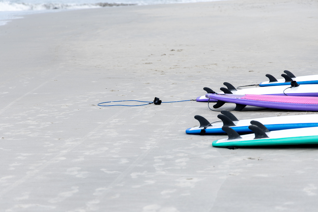 Pranchas coloridas organizadas na areia da praia