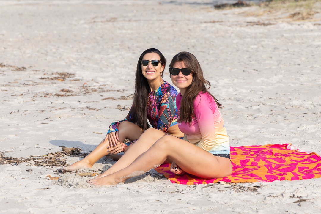 Duas amigas sentadas na praia depois do surf