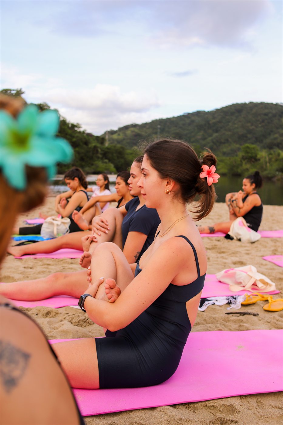 Mulheres em uma prática de movimento na praia durante o retiro